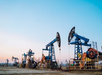 Several oil pumps in blue color on a clear sky background, great for a copy space. - stock photo